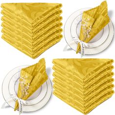 a stack of yellow napkins sitting on top of each other in front of a white plate