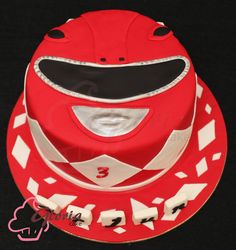 a red cake with white and black designs on it's face is sitting in front of a black background