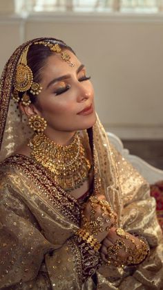 a woman in a bridal outfit with gold jewelry