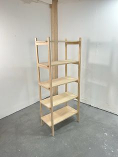 an unfinished shelving unit in a room with white walls and concrete flooring on the ground