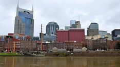 the city skyline is reflected in the water on a cloudy day with no people or vehicles