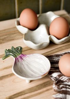 three eggs and an onion in a white bowl