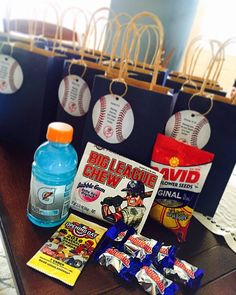 some snacks are sitting on a table with sports bags and drinks in front of them