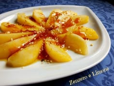 a white plate topped with sliced apples covered in sauce