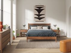 a bed room with a neatly made bed and wooden furniture