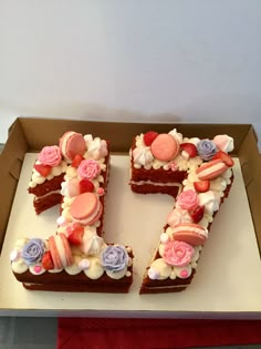 a cake shaped like the number seven with frosting and flowers on it in a box