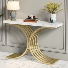 a white marble table with gold metal legs and a lamp next to it on a tiled floor