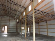 an empty warehouse with wooden beams and white walls