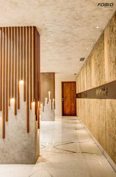 an empty hallway with wooden slats on the wall and marble flooring in front of it