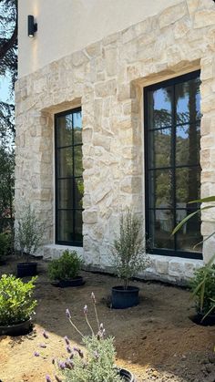 there are two windows in the side of this house that is made out of stone