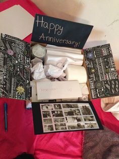 an open box with pictures and writing on it, sitting on a pink cloth covered bed