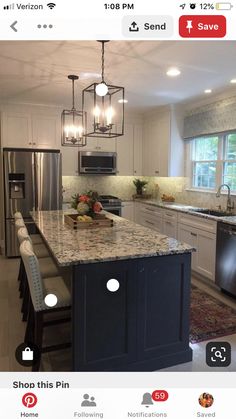 a large kitchen with an island in the middle and lots of lights hanging from the ceiling