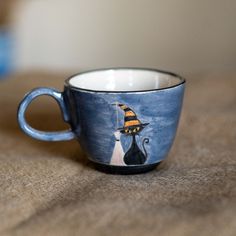 a coffee cup with a witches hat painted on it