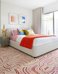 a white bed with colorful pillows in a bedroom