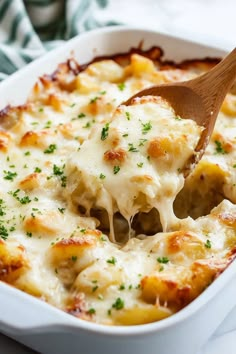 a wooden spoon scooping some food out of a casserole dish with cheese