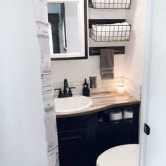 a bathroom with a toilet, sink and mirror