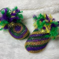 two pairs of slippers with colorful feathers on top of white fluffy fur covered floor