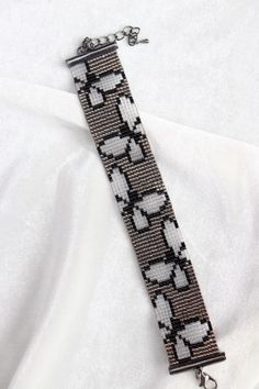 a black and white beaded bracelet on a white shirt with silver metal clasps