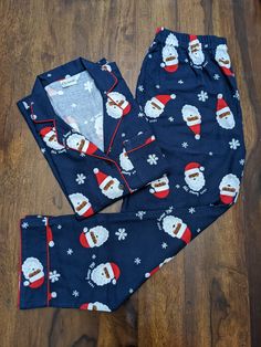 Soft flannel cotton dark-blue pajama sets for adults (uppers and lowers) with Santa and snowflakes. The santa pattern help to get you into the perfect winter holiday mood and the pockets help make it for a cozy experience.  MATERIAL: 100% soft cotton flannel (light brushed) CUSTOMIZATIONS: You can choose a standard shirt pocket or  one with the image of Santa. We are happy to make minor alterations to help you get the perfect fit. We can also accept bulk orders.  PLEASE NOTE what you get may not match exactly with the photos and may vary slightly in color and pattern due to lighting and camera settings. We try to be as true as possible to the photographs and are happy to answer any questions around the material or shade etc.   CARE: Wash in warm or cold water. Do not soak, bleach or wring. Blue Christmas Pajamas, Casual Christmas Sleepwear For Pajama Party, Cotton Pajama Party Sets For Winter, Cotton Pajama Sets For Winter Pajama Party, Cotton Pajama Sets For Winter Party, Cotton Sets For Pajama Party In Winter, Winter Sleepwear Sets In Relaxed Fit, Casual Christmas Sleepwear Relaxed Fit, Holiday Cotton Sets For Pajama Party