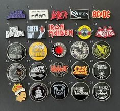 a collection of pins and badges on a black surface with white writing in the middle