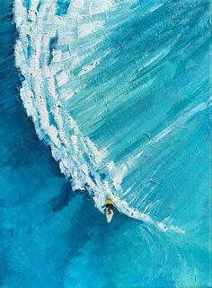 an aerial view of a person riding a wave on a surfboard in the ocean