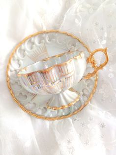 a cup and saucer sitting on top of a white table cloth