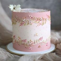 a pink and white cake with flowers on it