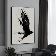 a black and white painting hanging on the wall above a chair in a living room