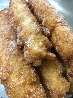 some type of fried food on a metal plate with powdered sugar over it's edges