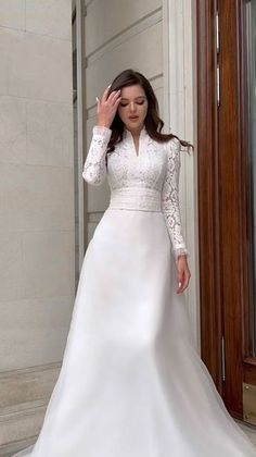 a woman in a white wedding dress is posing for the camera with her hand on her head