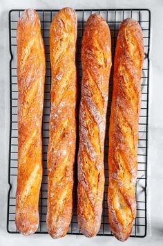 four loaves of bread on a cooling rack