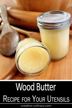 a jar of wood butter sitting on top of a wooden cutting board next to a spoon