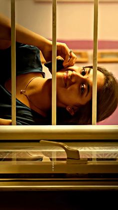 a woman leaning on the bars of a metal railing