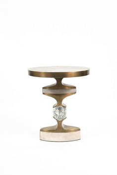 a small round table with a metal base and a white marble top on an isolated background