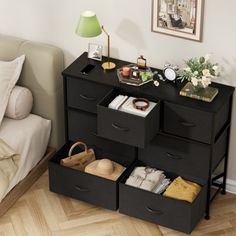 a bedroom with a bed, nightstand and drawers