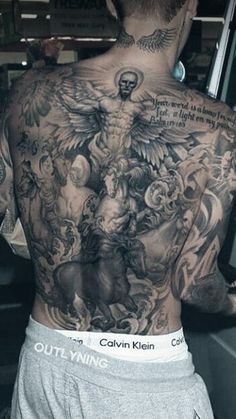 the back of a man with tattoos on his body