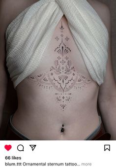 a woman's stomach with an intricate tattoo on her belly and the words, i like it ornament sternum tattoo more