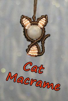 a cat ornament hanging from a chain with the words cat macrame on it