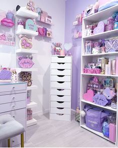 a room filled with lots of white furniture and purple accessories on shelving unit shelves