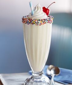 there is a milkshake with sprinkles and a cherry on top