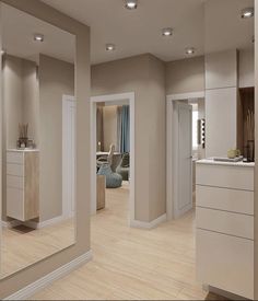 an empty living room and kitchen with large mirrors on the wall, in neutral colors