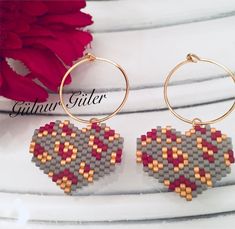 a pair of hoop earrings made out of legos and beaded with heart shaped beads