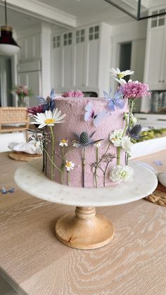 a pink cake decorated with flowers on a table