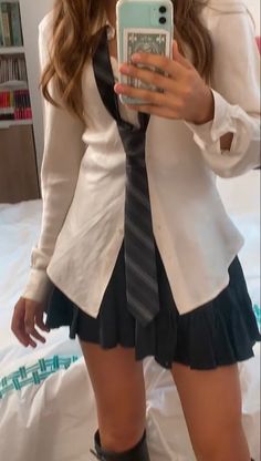 a woman taking a selfie with her cell phone wearing a skirt and shirt dress