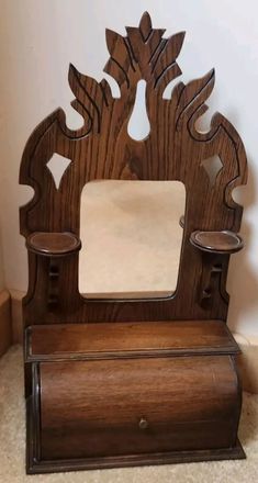 an old fashioned wooden mirror on top of a table