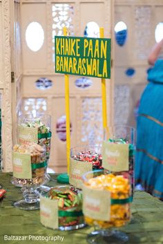 a table topped with lots of different types of food next to a sign that says khnke paan banarasmala