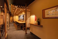 an empty restaurant with tables and chairs in the hallway, along with pictures on the wall