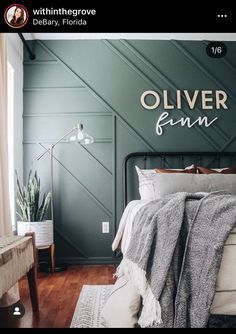 a bedroom with green walls and white bedding in the corner, along with a large rug on the floor