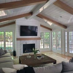 a living room with couches and a tv mounted on the wall above it's fireplace