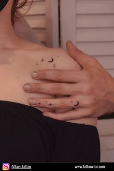 a woman's chest with two fingers and stars tattooed on her left side breast